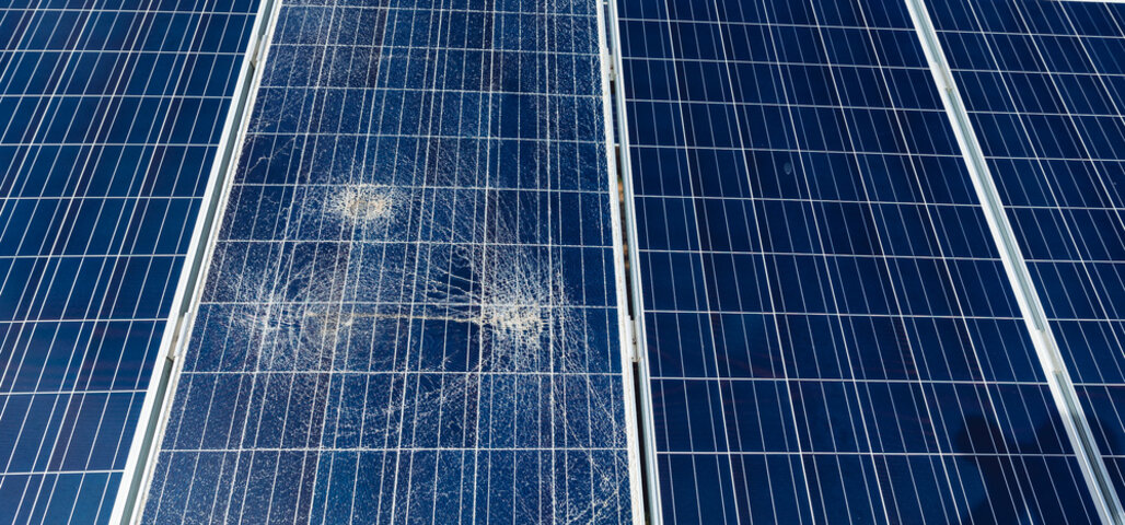 Broken destroyed cracked hole in solar panel after hail storm