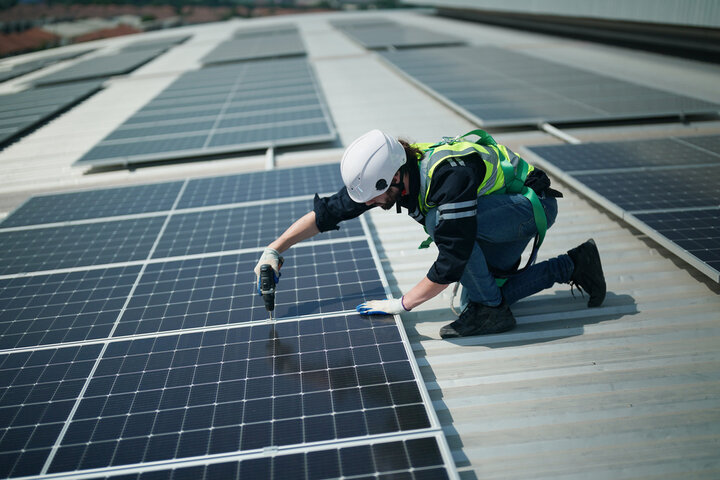 Professional worker installing solar panels on the roof